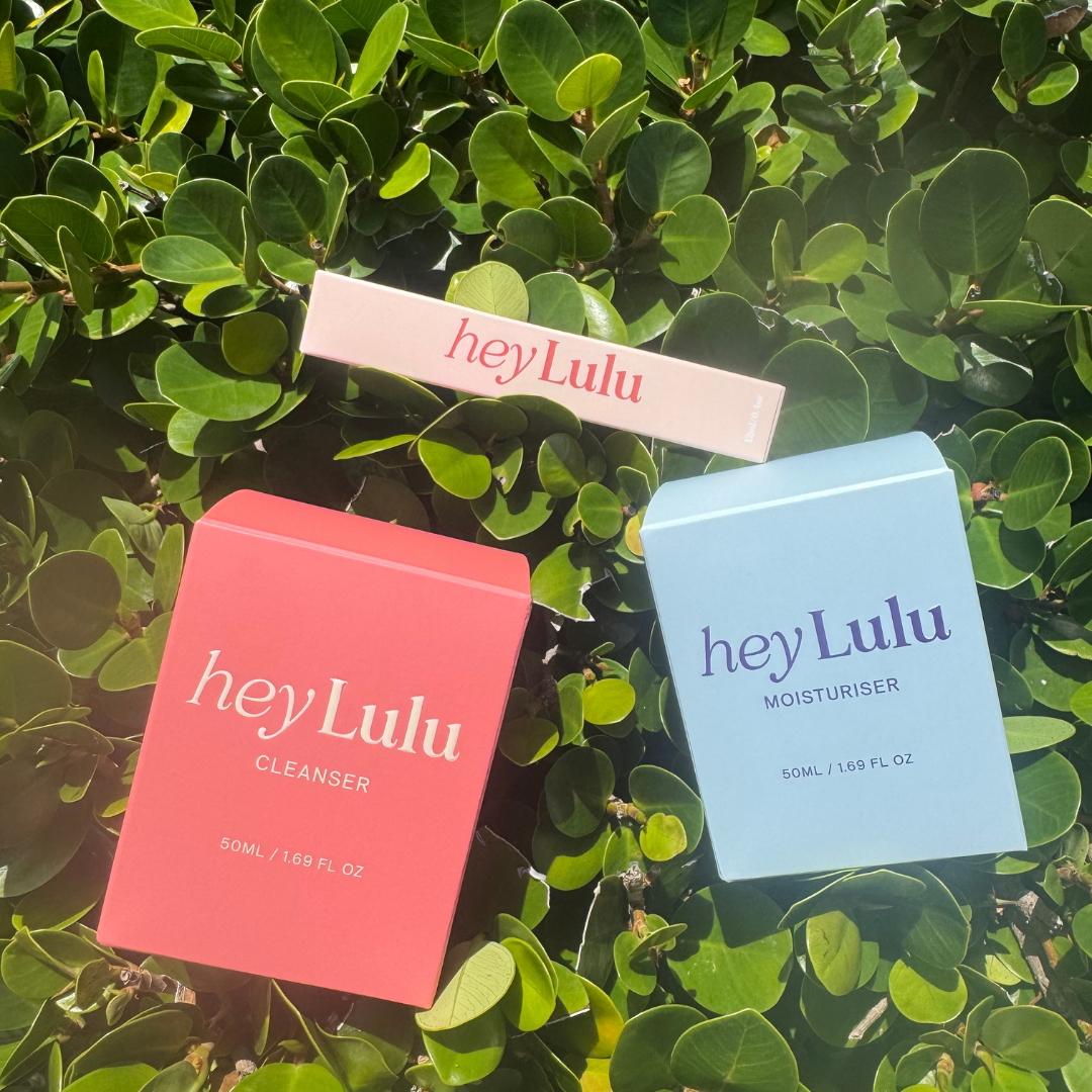 hey Lulu tween skincare essentials bundle with gentle cleanser, moisturiser and lip balm packaging styled together on a green leaf background