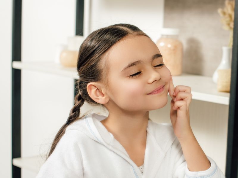 tween girl aged 8 in bathroom using skincare
